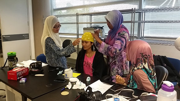 Ph.D. Students putting gel on electrocap
